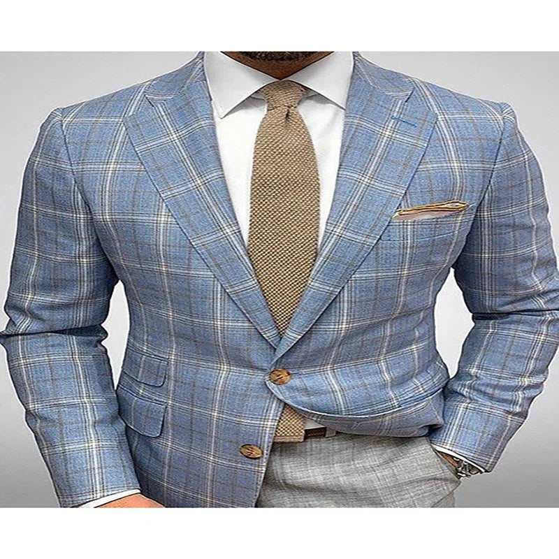 Man wearing blue plaid blazer with tan tie, white dress shirt, and gray pants