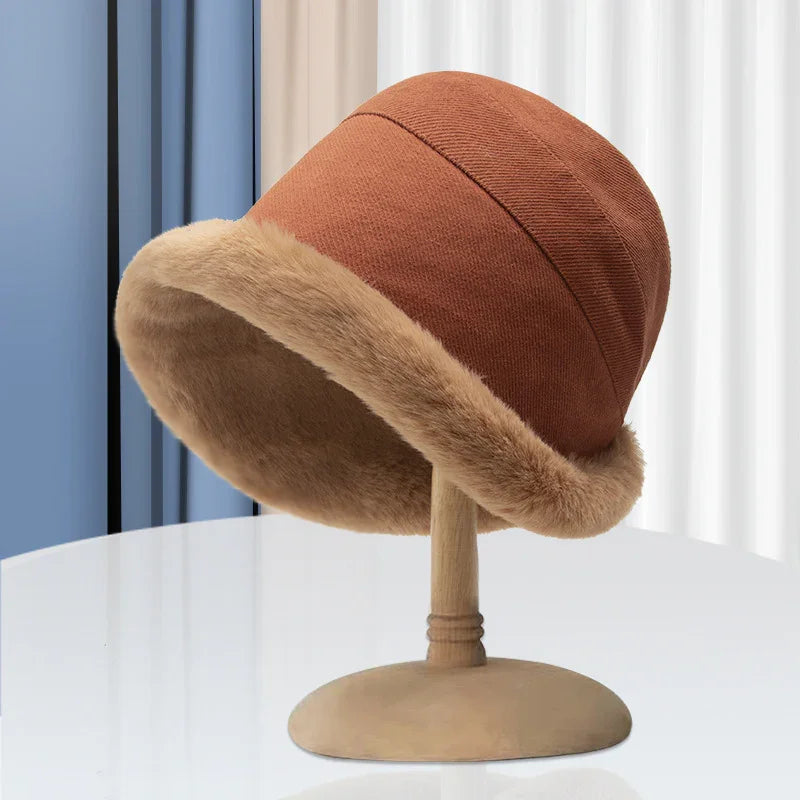 Brown winter hat with faux fur trim displayed on wooden mannequin stand