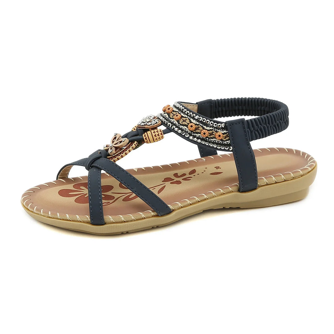 black strappy flat sandal with decorative beads and tan floral printed insole