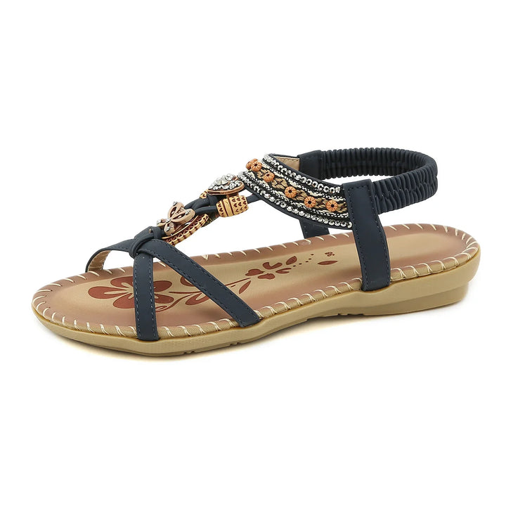 black strappy flat sandal with decorative beads and tan floral printed insole