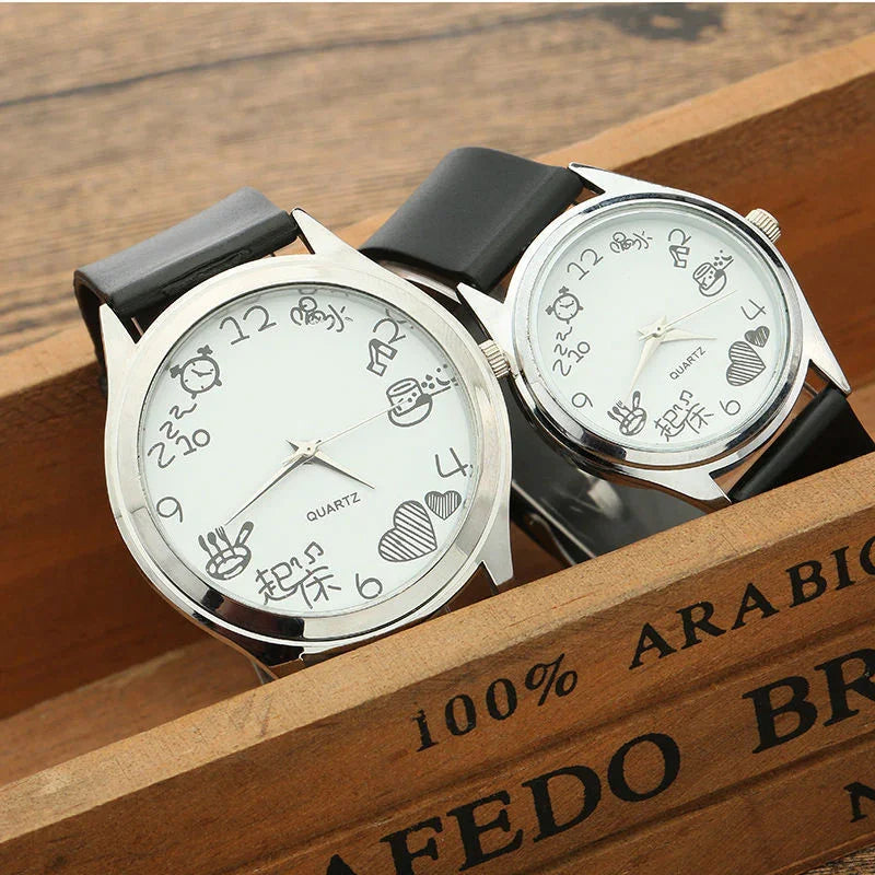 Two silver quartz wristwatches with black bands featuring playful cartoon hour markers on white dials
