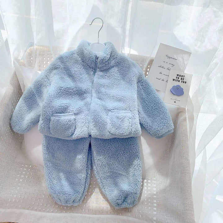 Soft light blue fleece baby outfit with jacket and pants on hanger in white basket