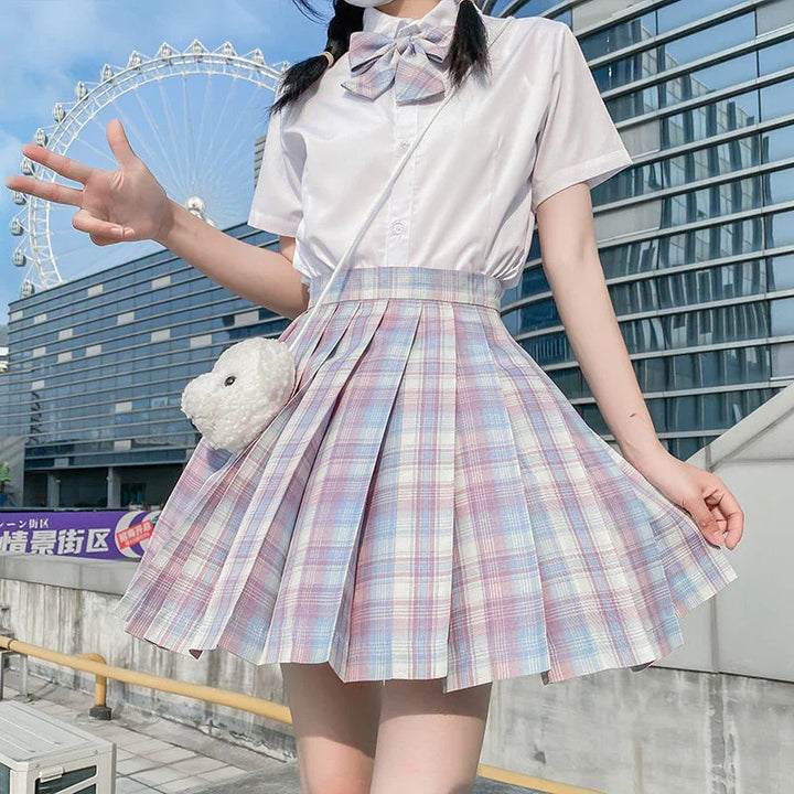 Young woman in pastel plaid pleated skirt and white blouse with bow, city Ferris wheel background
