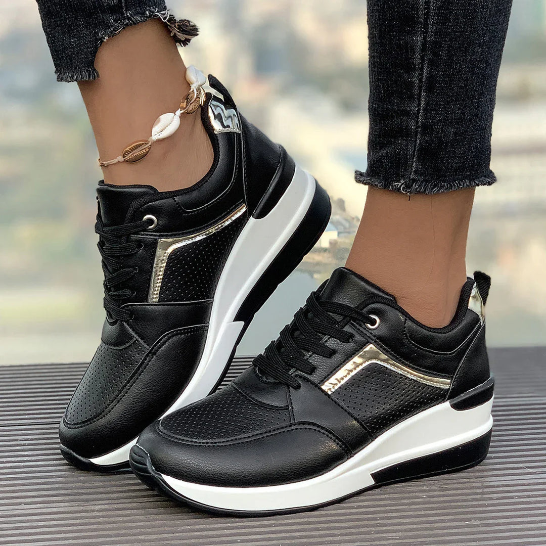 Black and white sneakers with gold accents worn with black frayed hem jeans and shell anklet
