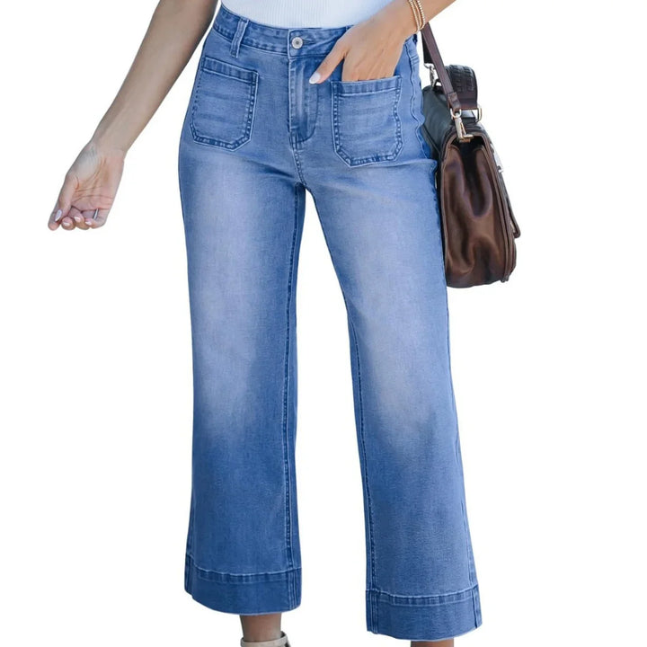 Woman wearing high-waisted light blue wide-leg jeans with front pockets and carrying brown leather handbag