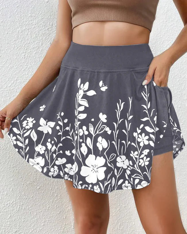 Gray skort with white floral print and side pocket worn by woman with tan crop top