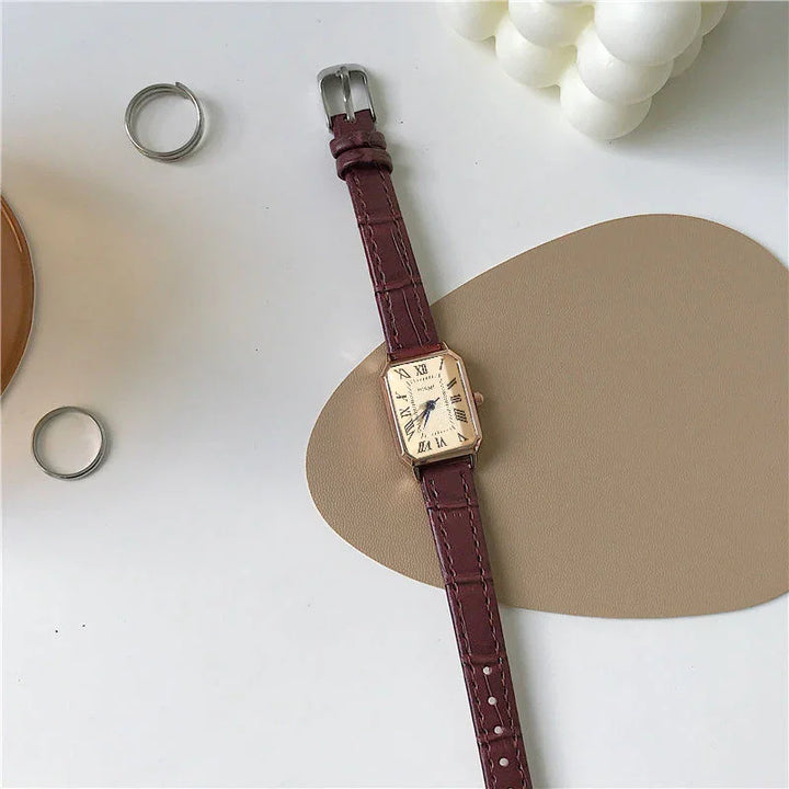Elegant rectangular watch with burgundy leather strap and Roman numerals on white dial