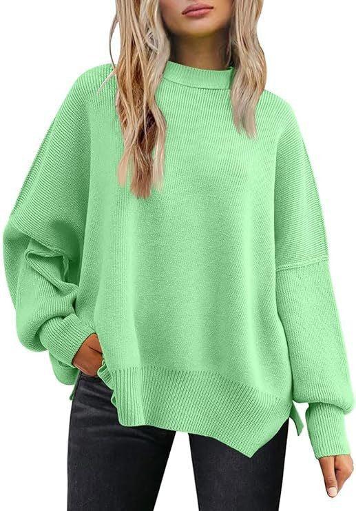 Woman wearing oversized mint green knitted sweater with long sleeves and black pants
