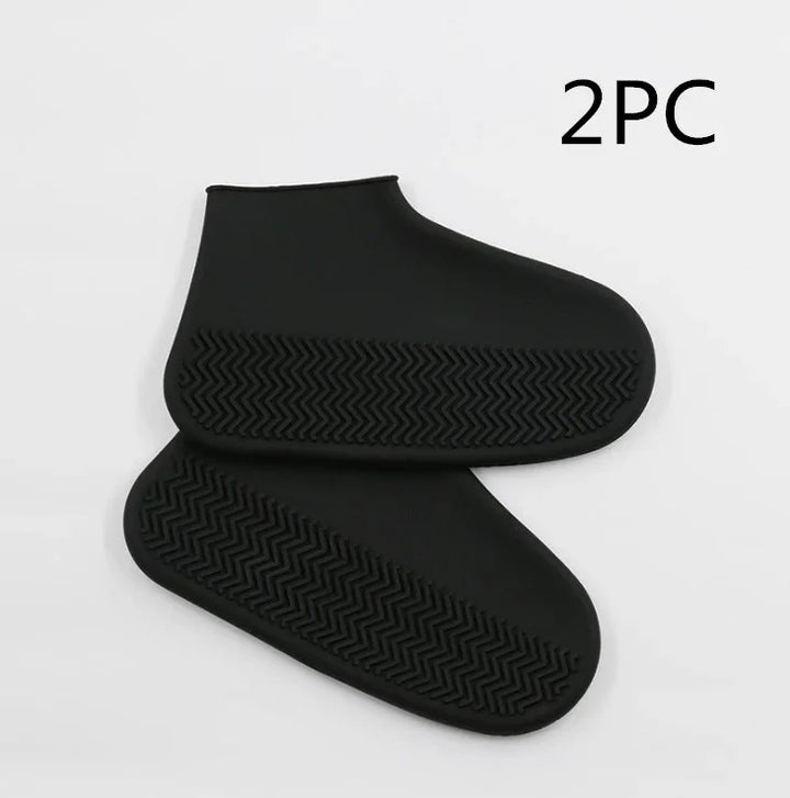 Pair of black silicone waterproof shoe covers with textured non-slip soles on white background