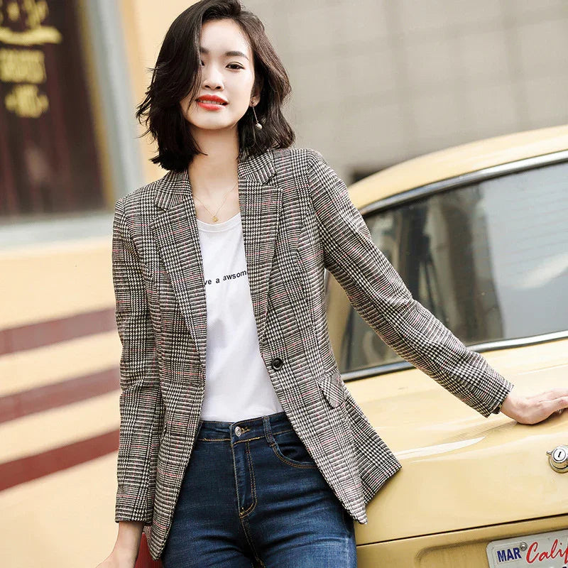 Young woman in plaid blazer and white graphic tee leaning on vintage yellow car outdoors