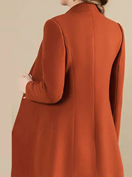 Back view of woman wearing a stylish burnt orange long coat with tailored fit