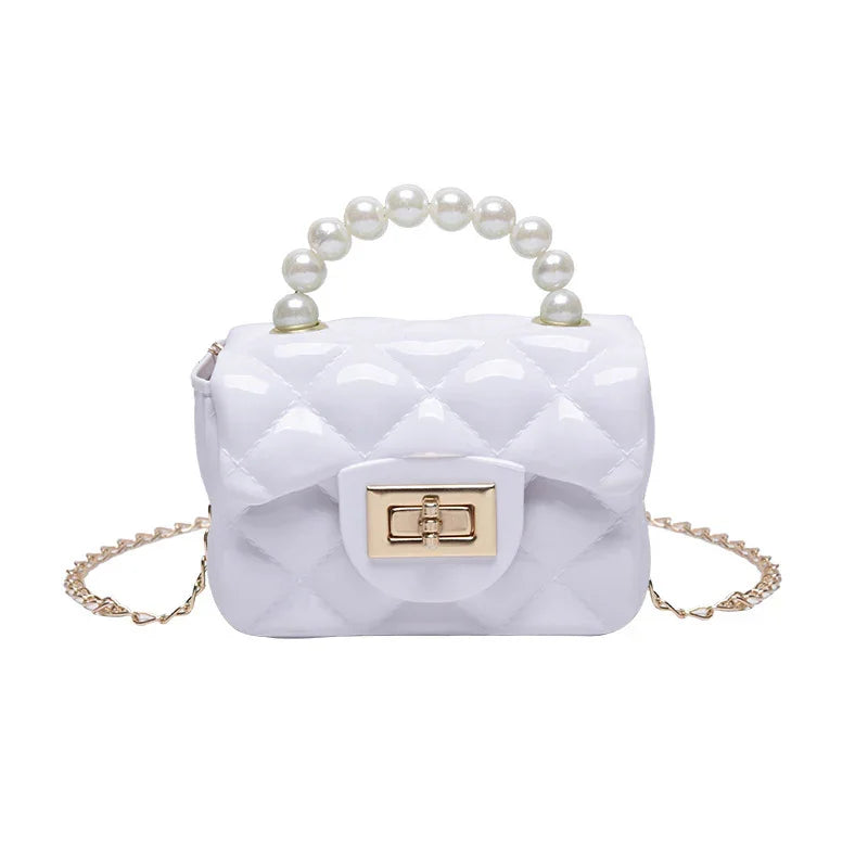 White quilted handbag with pearl handle and gold chain strap on white background