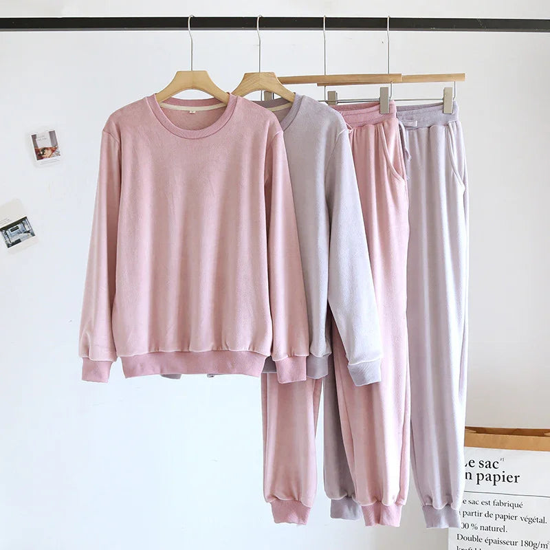 Soft fleece long sleeve sweatshirts and matching jogger pants in pastel pink and light gray on wooden hangers