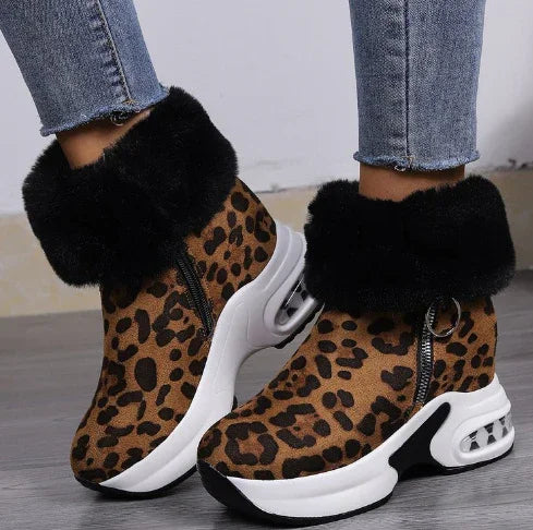 Leopard print winter sneakers with black fur trim and white chunky air-cushioned soles worn with blue jeans
