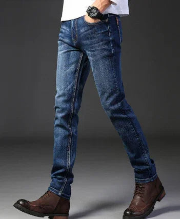 Slim fit dark blue denim jeans worn with brown leather boots and white shirt