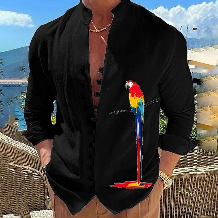 Man wearing black Mandarin collar shirt with colorful melting parrot graphic, outdoor patio and mountain background