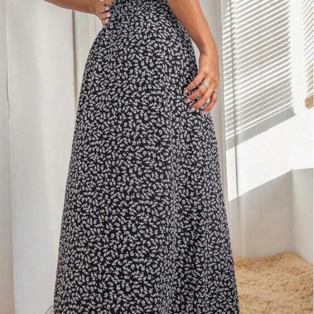 Close-up of woman wearing high-waisted black maxi skirt with small white floral print in bright room