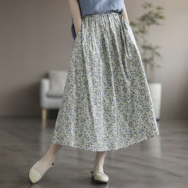 Woman wearing a long floral skirt with elastic waist and beige flats in a minimalist room