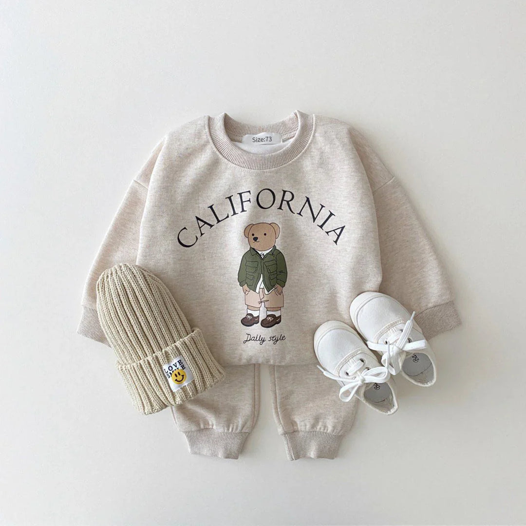 Beige toddler outfit with California bear sweatshirt, pants, knit hat, and white shoes