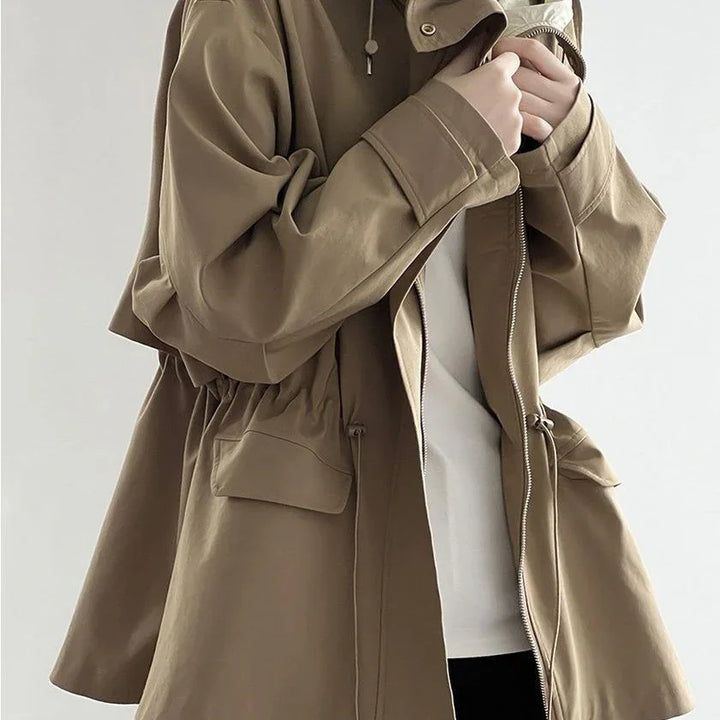 Close-up of person wearing stylish tan hooded jacket with zipper and flap pockets
