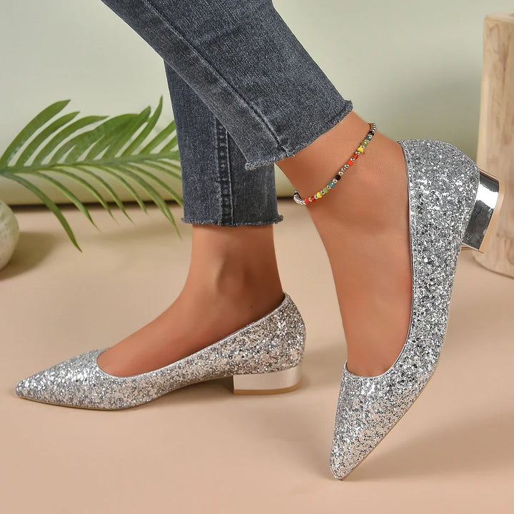 Silver glitter low heel pointed toe shoes worn with dark frayed hem jeans and colorful beaded ankle bracelet