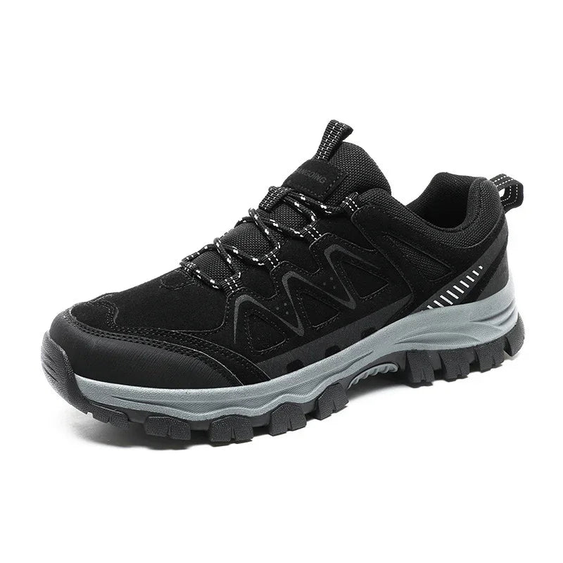 Black rugged outdoor hiking shoe with gray sole and reflective details on white background