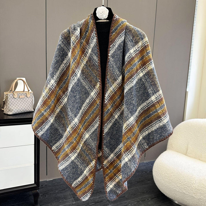 Plaid wool shawl with brown, white, and gray stripes displayed on mannequin in modern room