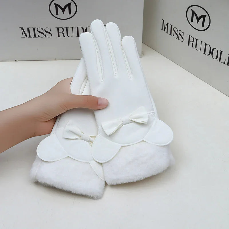 White winter gloves with fluffy cuffs and bow detail held in hand, branded Miss Rudolf