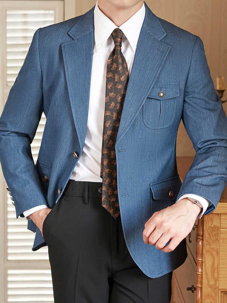 Man wearing blue blazer with buttoned pockets, white dress shirt, and patterned brown tie, black pants