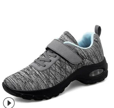 Grey athletic sneaker with strap and air-cushioned black sole, breathable knit fabric upper