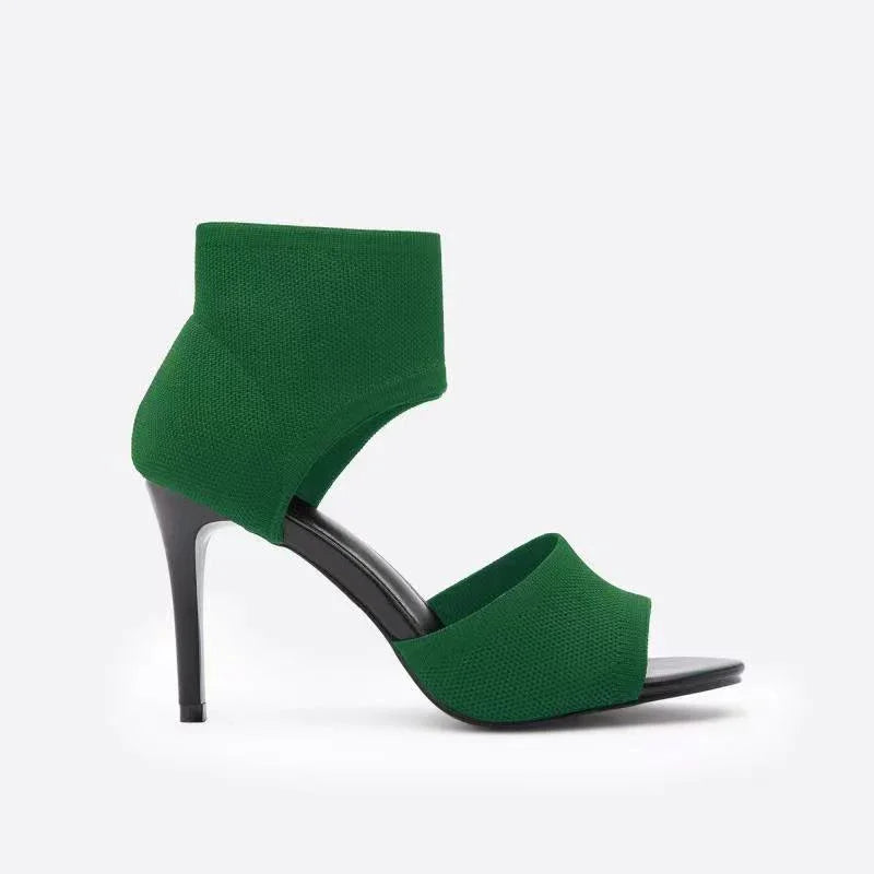 Green high-heeled sandal with ankle strap and open toe on white background