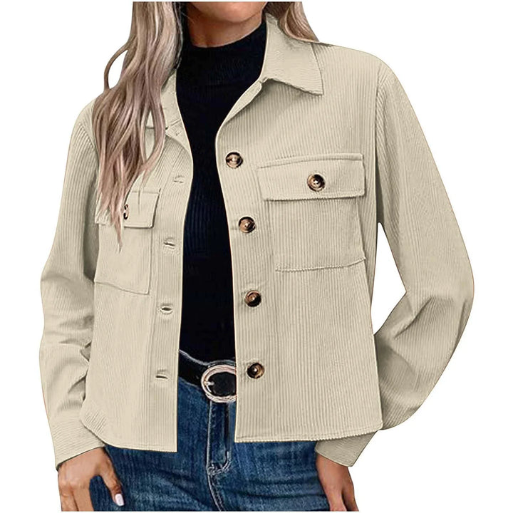 Woman wearing beige corduroy button-up jacket with flap pockets over black top and blue jeans