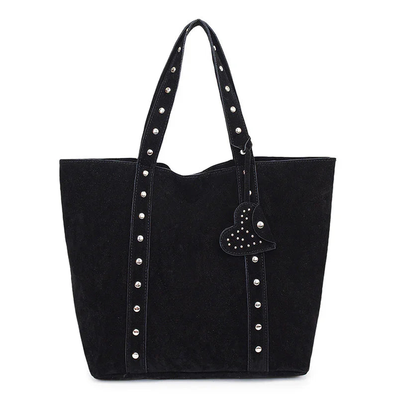 Black suede tote bag with silver studs on straps and heart-shaped studded charm