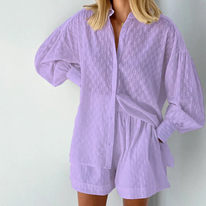 Woman wearing light purple textured button-up shirt and matching shorts in minimal setting