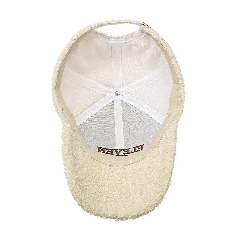 Cream-colored sherpa fleece baseball cap with visible inner white lining and strap