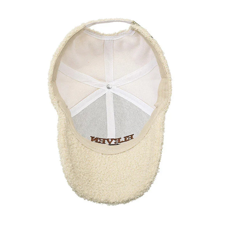 Cream-colored sherpa fleece baseball cap with visible inner white lining and strap
