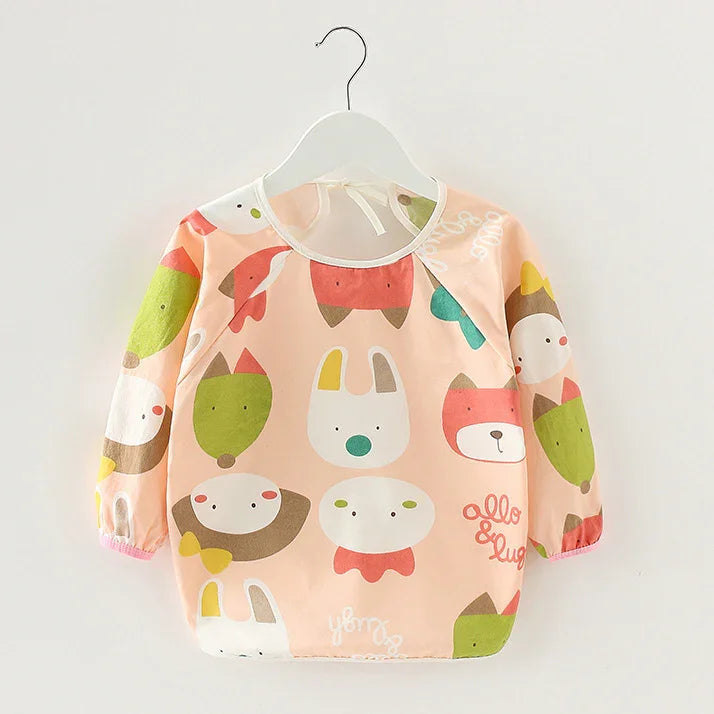 Long-sleeve baby bib with colorful animal face prints on peach background hanging on white hanger
