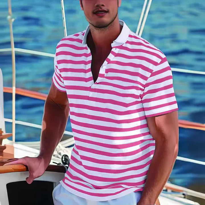 Man wearing pink and white striped polo shirt on a sailboat with ocean backdrop