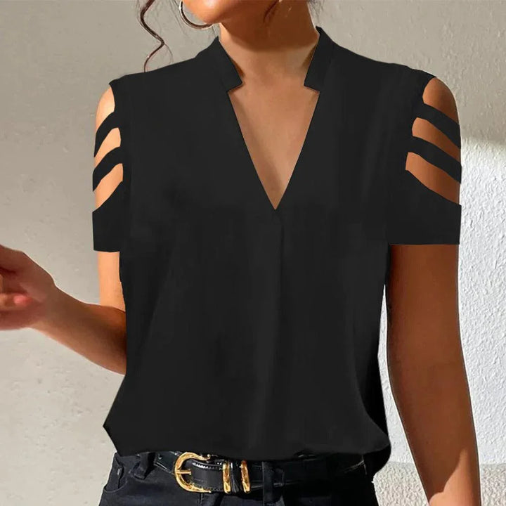 Woman wearing black cold shoulder blouse with V-neck and triple strap sleeve design