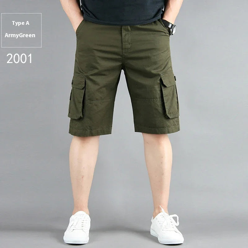 Man wearing army green cargo shorts and white sneakers against gray background