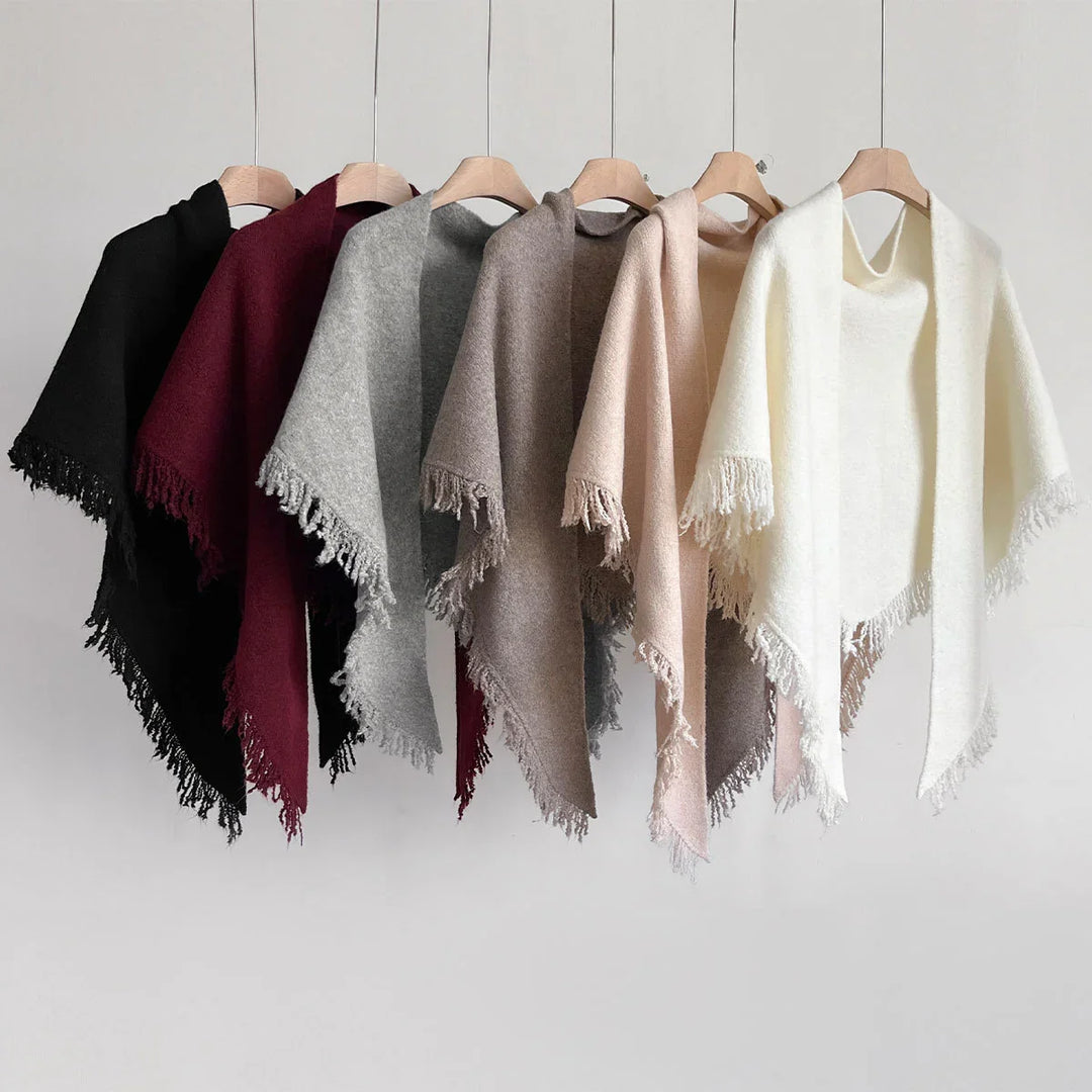 Soft wool fringe shawls in black, burgundy, grey, brown, beige, and white colors hanging on wooden hangers