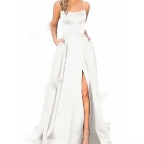 Woman wearing elegant white sleeveless gown with fitted bodice and high front slit