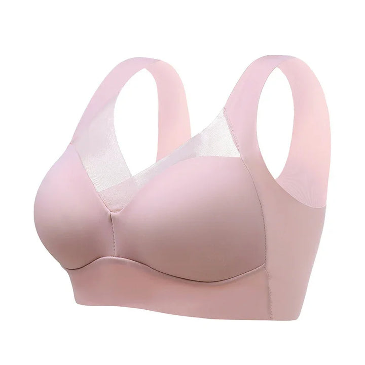 Light pink seamless wireless bra with mesh panel and wide straps on white background