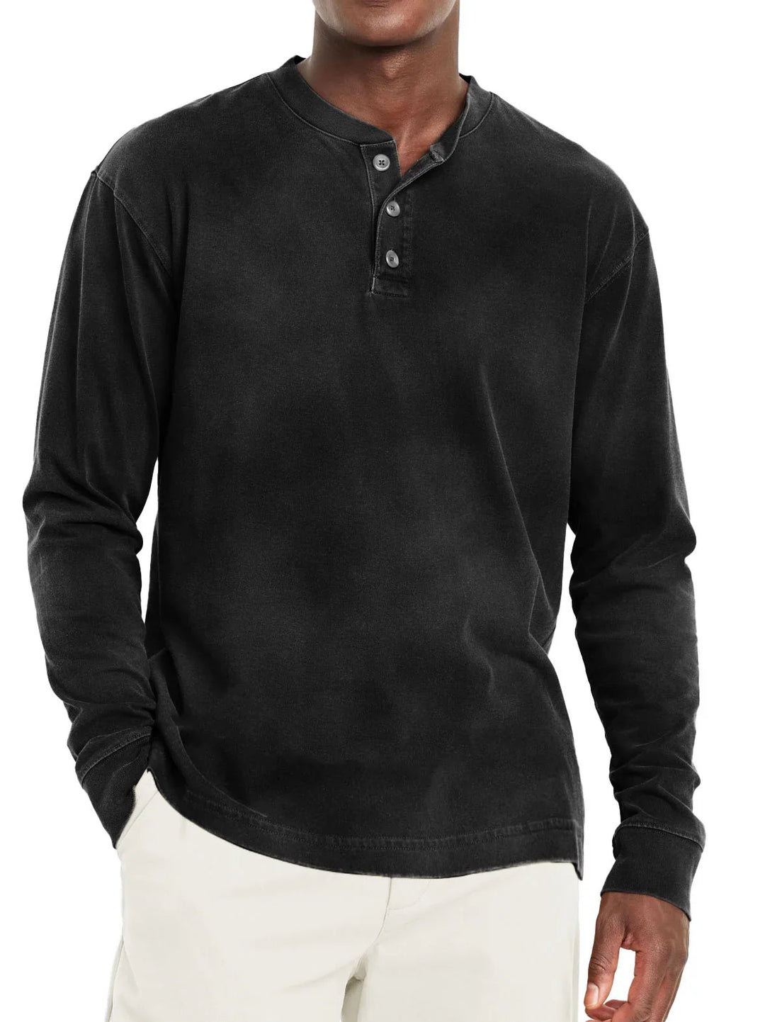Man wearing black long-sleeve henley shirt with buttoned placket and beige pants
