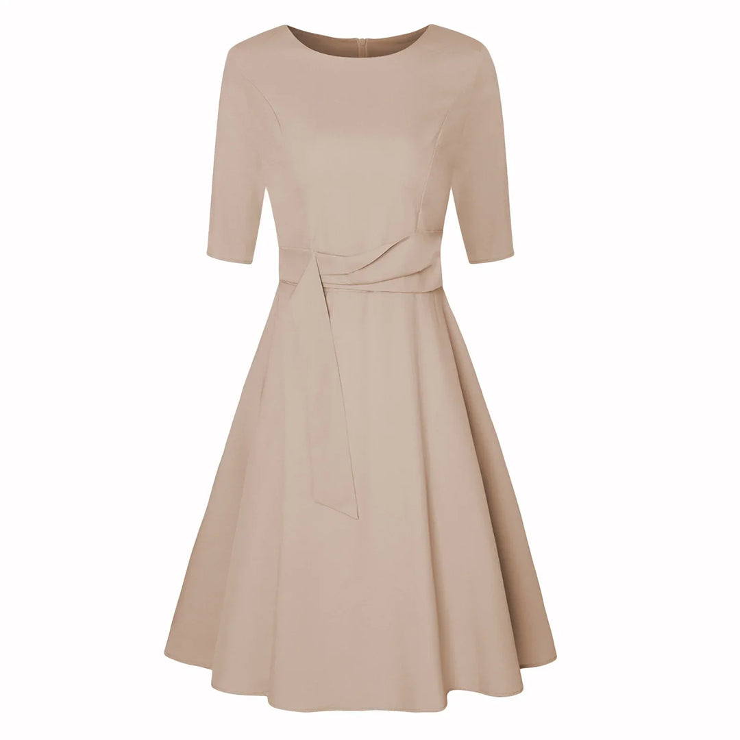 Beige knee-length dress with half sleeves, boat neckline, fitted waist, and flared skirt