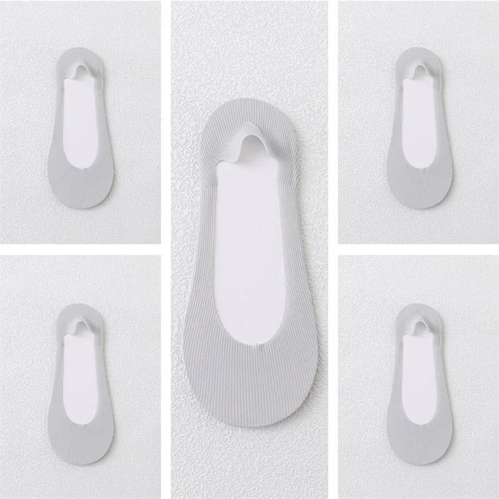 Multiple white no-show ankle socks with ribbed texture on a textured white background