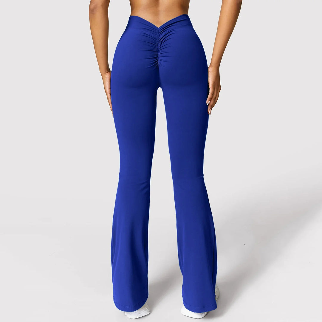 Back view of woman wearing royal blue scrunch high-waisted flare leggings against white background