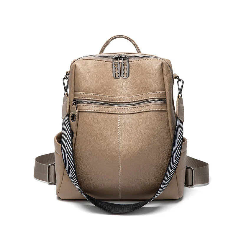 Beige leather backpack with front zipper pocket and black-and-white patterned shoulder strap