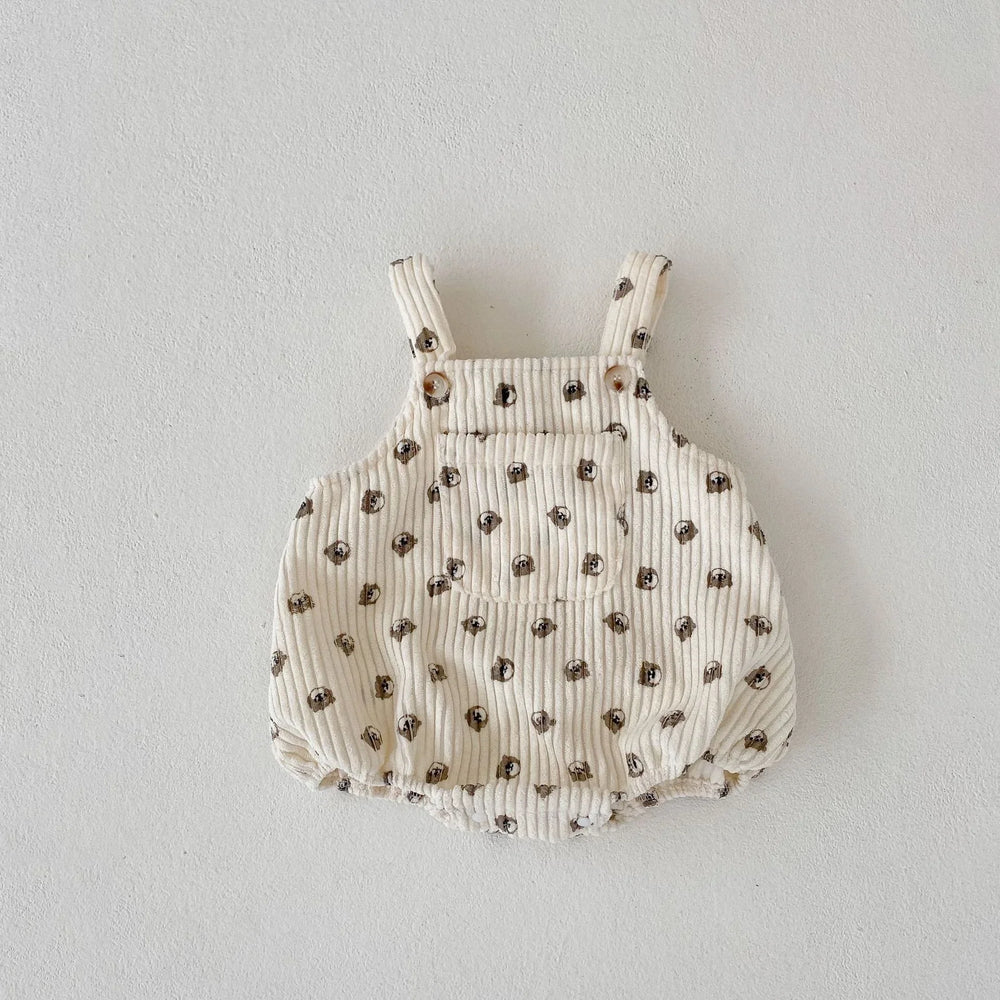 Beige baby romper with brown dog face print and front pocket on textured fabric