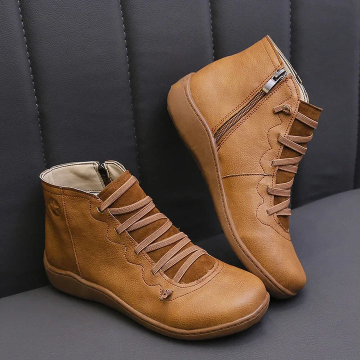 Brown lace-up leather ankle boots with side zipper on black leather seat